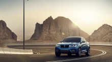 Яркое солнце прячется за скалой позади нового BMW X4